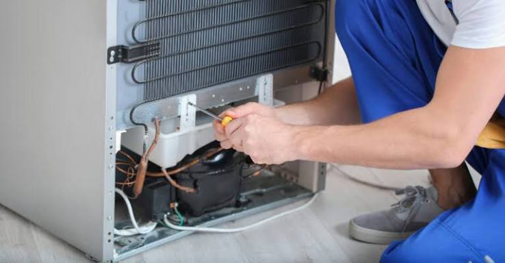 Técnico verificando o sistema traseiro de uma geladeira